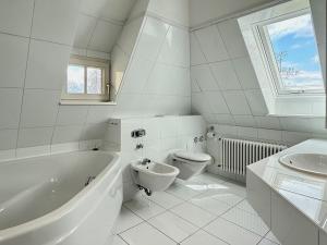 a bathroom with a tub and a toilet and a sink at Ferienwohnung Seeperle49 WG2 - Besonders, stilvoll mit eigenem Badestrand in Nonnenhorn +31 photos