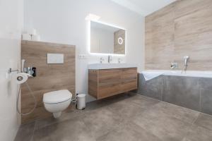 a bathroom with a toilet and a sink and a tub at Amaria Downtown Aparthotel Villach in Villach +44 photos