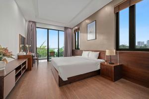 a bedroom with a bed and a desk and windows at Villa Da Nang Hoang Sa in Da Nang +7 photos