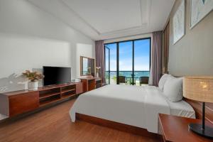 a bedroom with a large bed and a large window at Villa Da Nang Hoang Sa in Da Nang