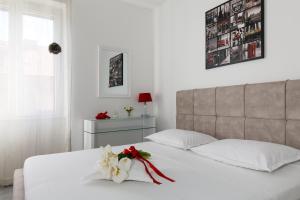 ein Schlafzimmer mit einem weißen Bett mit einer Blume darauf in der Unterkunft Apartments Kala & Kaleta in Split