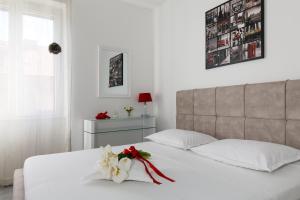 a bedroom with a white bed with a flower on it at Apartments Kala & Kaleta in Split