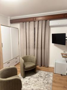 a living room with a chair and a television at Residencial Pôr do Sol in Couço
