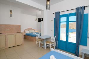 a living room with a blue door and a bedroom at levante studios 2 in Amorgos