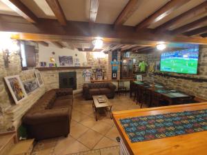 a living room with couches and a tv and a bar at El Hogar del Ciclista in Espinosa de los Monteros