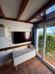 a living room with a tv and a large window at Maison de la mer in Hendaye