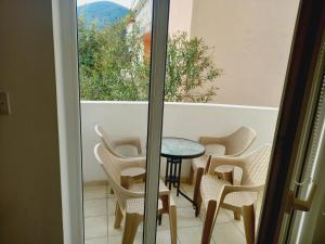 a balcony with chairs and a table and a window at B4 in Budva