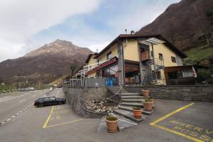 un edificio sul lato di una strada accanto a una montagna di Osteria Posse a Lavertezzo
