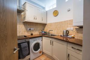 eine Küche mit Waschmaschine und Spüle in der Unterkunft Harbour-side, 2-bed Mews Apartment, in Torquay