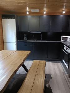 a kitchen with a wooden table and a refrigerator at Villa Särkkä in Kalajoki