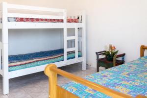 a bedroom with two bunk beds and a bed at Pitangueiras Frente Total Mar pé na areia in Guarujá