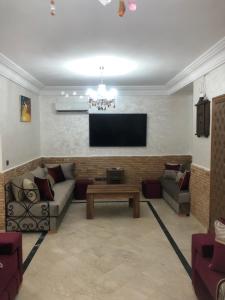 Una sala de estar con un sofá y un televisor de pantalla plana. en Résidence Babylone Y - Appartement 2 Chambres, en Marrakech