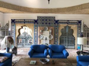 a living room with blue furniture and a wall covered in tiles at Dream House by the Aegean Coast in Dikili