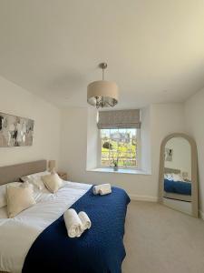 阿尔弗斯顿Lonsdale House Boutique Apartments的一间卧室，有一张大床，床上有两条毛巾