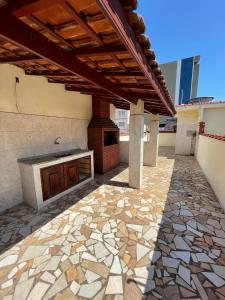 an outdoor patio with a stone floor and awning at Casa a 2 minutos do santuário Nossa Senhora aparecida in Aparecida