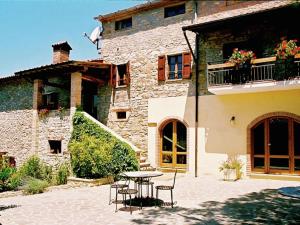 Monte Santa Maria TiberinaにあるFarmhouse in Monte s Maria Tiberina with stablesの建物前のテーブルと椅子