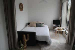 a bedroom with a bed and a cactus in it at Appartement cosy terrasse parking privé 2 vélos in La Rochelle