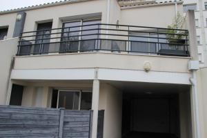 a white building with a balcony and a door at Appartement cosy terrasse parking privé 2 vélos in La Rochelle