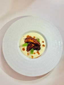 a white plate with a dish of food on it at Hotel Butterfly Wellness & Spa in Rimini