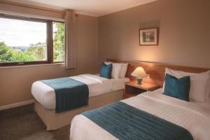 a hotel room with two beds and a window at Rutland Hall Hotel & Spa in Burley