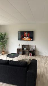 a living room with a couch and a tv on a wall at Casa Egevænget - 400 meters to LEGO HOUSE and Shopping in Billund