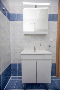 a bathroom with a white sink and a mirror at Angelica's Apartment in Asprovalta +19 photos