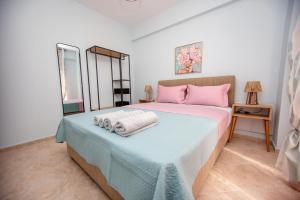 a bedroom with a bed with two towels on it at Angelica's Apartment in Asprovalta