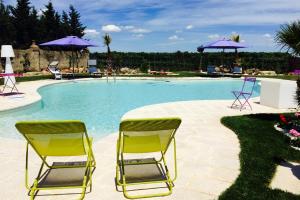 a row of chairs sitting in front of a pool at Le Scuderie - Castello Monaci in Salice Salentino