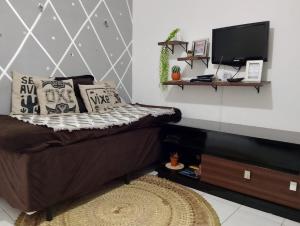 a living room with a couch and a television at Apartamento da Jack in Campina Grande