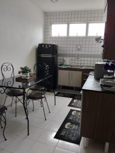a kitchen with a table and chairs and a refrigerator at Apartamento da Jack in Campina Grande