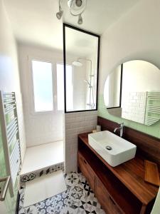 een badkamer met een wastafel en een spiegel bij Appartement Ajaccio vue mer in Ajaccio
