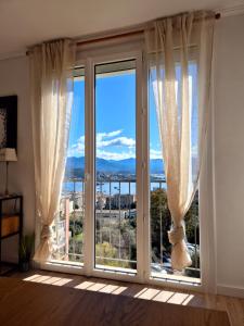 een kamer met een groot raam met uitzicht bij Appartement Ajaccio vue mer in Ajaccio