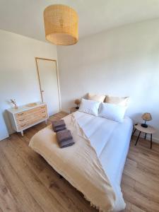 een slaapkamer met een groot wit bed met handdoeken erop bij Appartement Ajaccio vue mer in Ajaccio