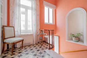 a hallway with orange walls and a chair and a floor at Neoclassical Mansion in Andros Town by Explore Andros in Andros