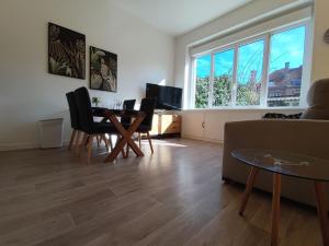 a living room with a table and chairs and a couch at TOK TOK S1 Appartement 1Ch Moderne Plein Centre in Seclin