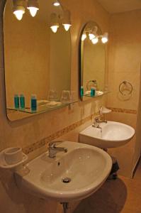 La salle de bains est pourvue d'un lavabo blanc et d'un miroir. dans l'établissement Luciano Valletta Boutique, à La Valette