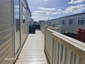 a walkway next to a train station with two trains at 3-Bed Caravan Sleeps 8 Pool & Beach in Chapel Saint Leonards