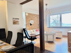 a dining room and living room with a table and chairs at Ferienwohnung Seeperle49 - Besonders, stilvoll mit eigenem Badestrand in Nonnenhorn