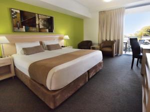 Giường trong phòng chung tại Oaks Townsville Gateway Suites