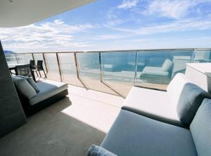 a balcony with a couch and chairs on a yacht at Sunset Cliffs - Vida de Luxury in Benidorm