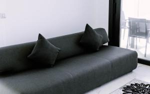 a couch with four pillows sitting in a living room at Sunset Cliffs - Vida de Luxury in Benidorm