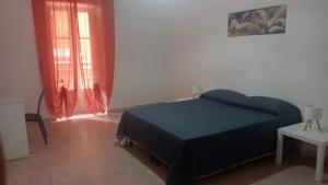 una camera da letto con un letto con una coperta blu di Penelope a Agrigento