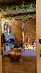 a living room with a fireplace and a wooden table at Casa Antón O Cebreiro in O Cebrero
