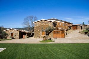 a large brick house with a grass yard at Refúgios do Pinhal in Oleiros