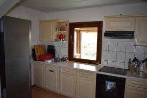 a kitchen with white cabinets and a sink and a window at Ferienhaus Bella Vista Edersee in Vöhl