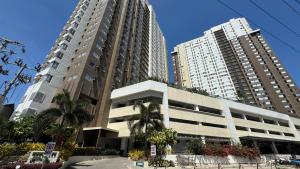 two tall buildings in a city with palm trees at Namco City Suite in Cagayan de Oro
