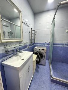 a bathroom with a sink and a washing machine at Family House in Stantsiya Kyzyl-Tukumachi +3 photos
