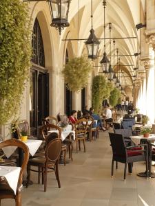 a restaurant with tables and chairs and people sitting at tables at Cracow Route #2 - Old Town in Kraków