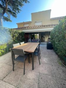un tavolo in legno con sedie di fronte a una casa di Maisonnette cosy piscine parking ad Argelès-sur-Mer