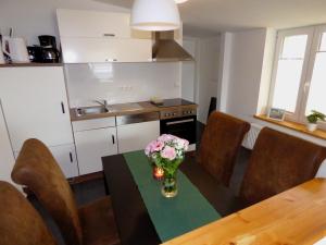 a kitchen with a table with a vase of flowers on it at Emely Ferienwohnungen in Röbel